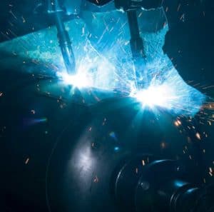 View of a robot at work inside a robotic welding cell