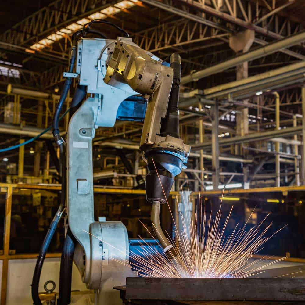 Robotic weld cell in use, creating sparks and fumes