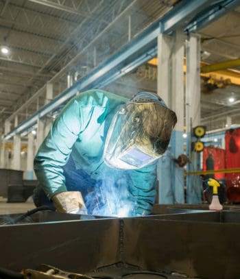 Welder at work generating fumes being captured by DeltaMAXX cartridge filters for welding fume.