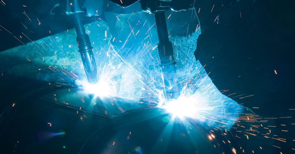 Robot welder in use under a fume exhaust hood