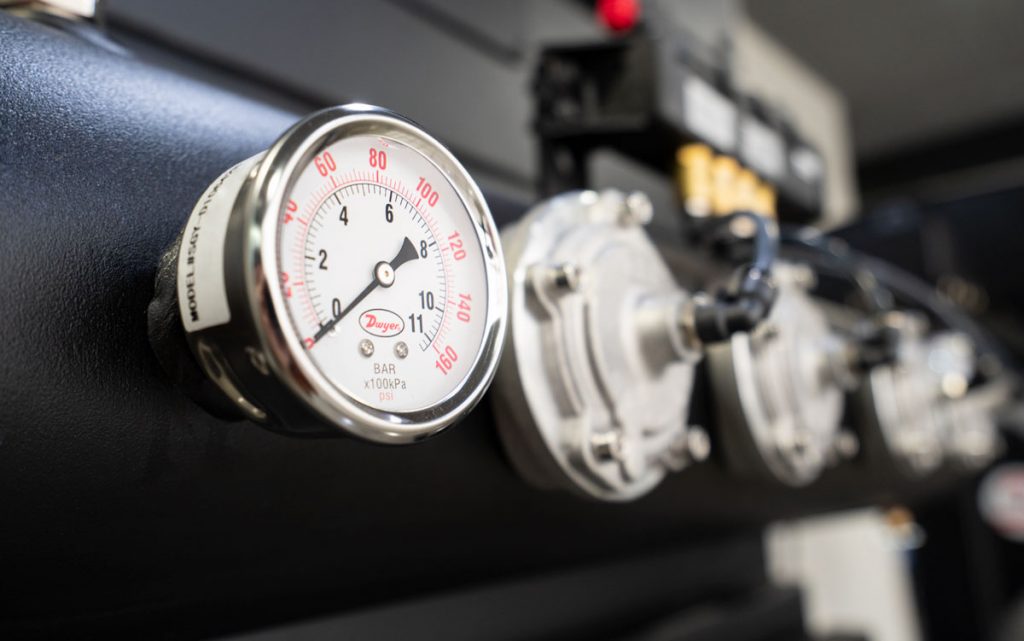 a differential pressure gauge mounted on an industrial dust collector to monitor filter resistance