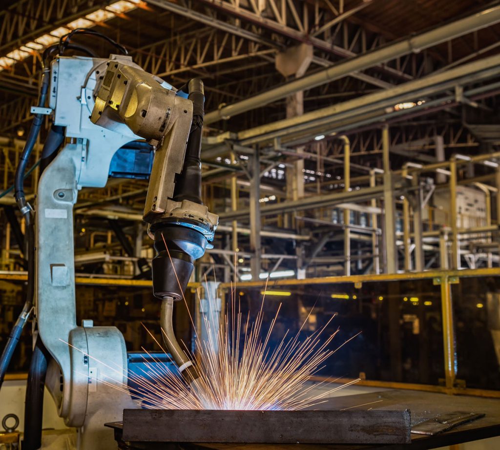 A cobot welding in a manufacturing environment.