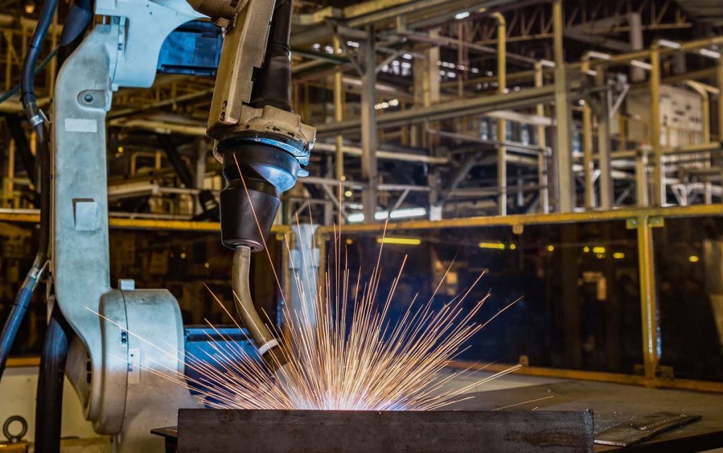 A cobot welding in a manufacturing environment.