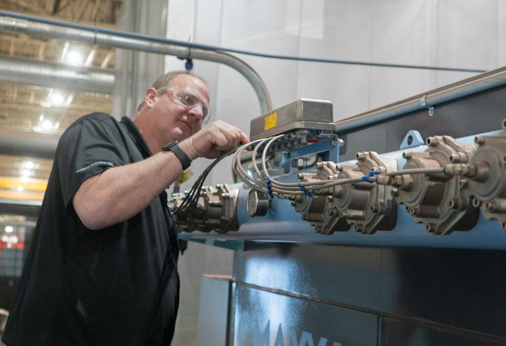 Technician troubleshooting a dust collector on an Imperial Systems CMAXX unit.